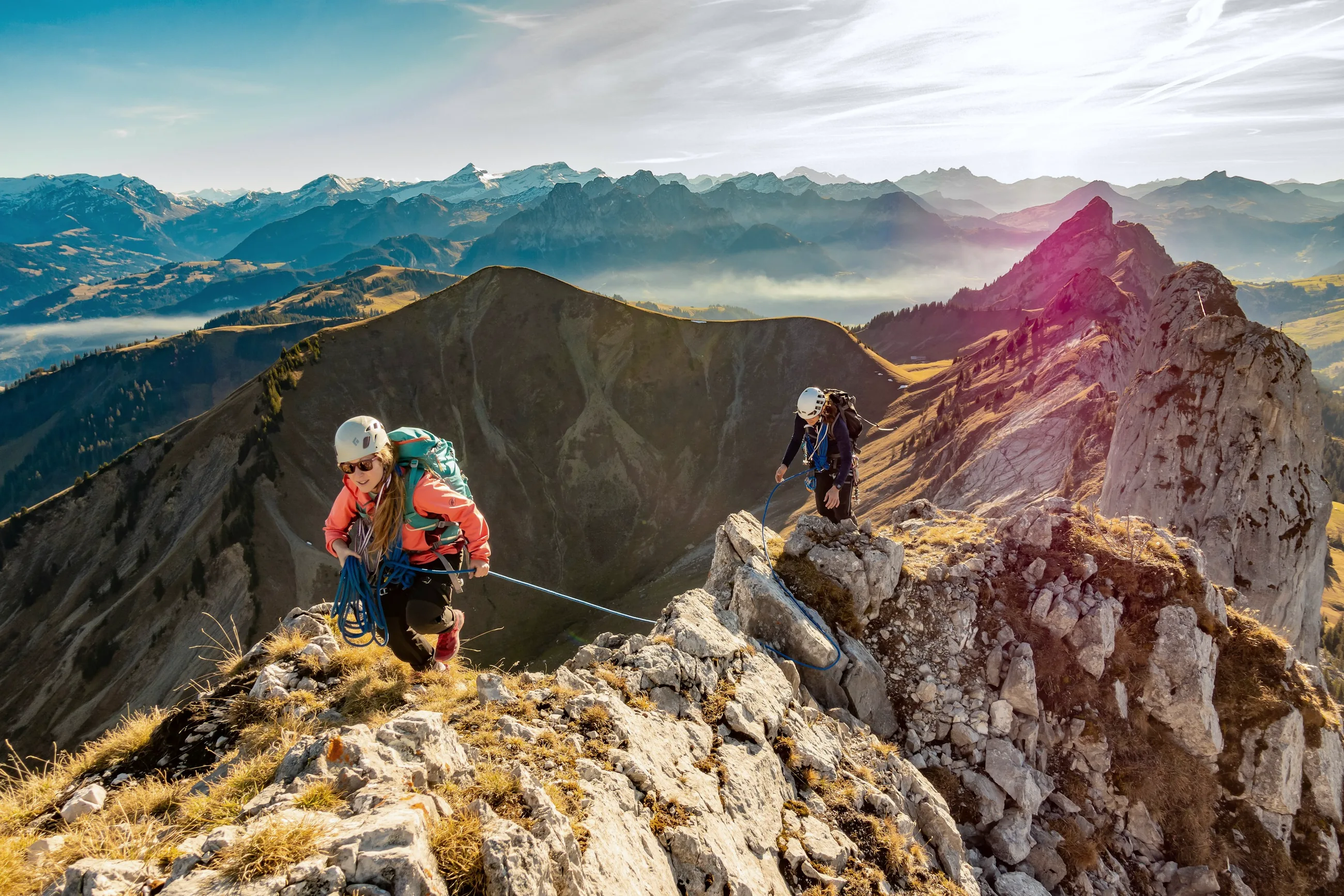 Two climbers roped together on a limestone ridge high above the clouds
